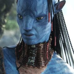 the blue man from avatar is wearing braids on his head and looking at the camera