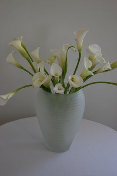 a white vase filled with flowers on top of a table