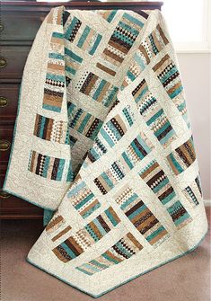 a quilted blanket sitting on top of a wooden dresser