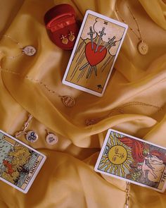 three tarot cards are laying on a yellow cloth