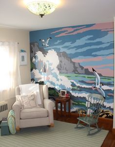 a living room filled with furniture and a large painting on the wall behind a rocking chair