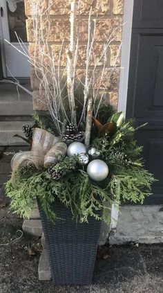 a basket filled with christmas decorations sitting on top of a stone floor next to a door