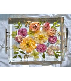 a clear tray with flowers and leaves on it