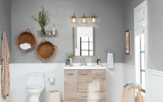 a white toilet sitting next to a wooden cabinet in a bathroom on top of a hard wood floor