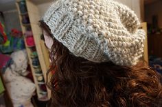 a close up of a person wearing a knitted hat in a room full of stuffed animals