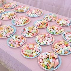 a table topped with lots of plates filled with candy