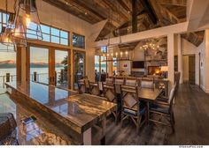 a large dining room table with chairs next to an open kitchen