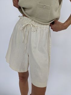 Easy buttercream shorts set in a woven linen material. The shorts have a gathered waistline with a drawstring waist, and long relaxed drape. Tag reads Roo Crossing Long Linen Shorts, Chic Beige Linen Shorts, Beige Linen Shorts For Beach, Beige Linen Shorts For The Beach, Beige Summer Shorts With Elastic Waistband, Summer Beige Shorts With Elastic Waistband, Neutral Linen Shorts For Spring, Neutral Linen Shorts For Summer, Spring Neutral Linen Shorts