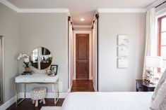 a white bed sitting next to a wooden door in a bedroom on top of a hard wood floor