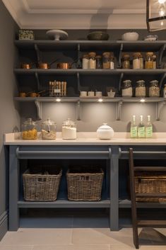 a kitchen with lots of shelves and baskets on the counter