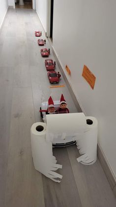 several toy cars lined up on the floor next to each other in a long hallway