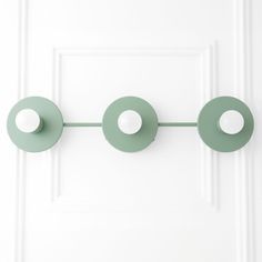 three green circles hang on a white door