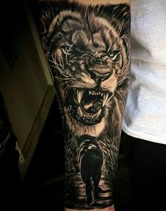 a man's arm with a tattoo of a tiger and an animal on it