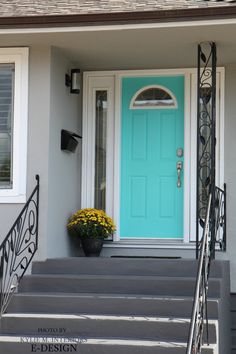 a blue front door and steps leading up to a house with flowers in the pot