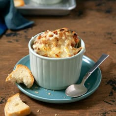 a bowl of food on a plate with bread