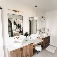 a bathroom with two sinks, mirrors and rugs on the floor in front of them