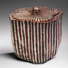 a brown and white vase with stripes on it