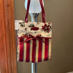 a red and white striped bag on a stand with a light bulb in the background