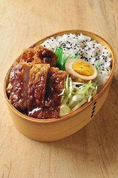 a wooden bowl filled with rice and meat