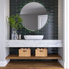 a white sink sitting under a round mirror on top of a wooden shelf next to a wall