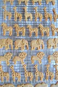 some cookies are cooling on a rack and have giraffes cut out of them