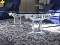 a glass coffee table sitting on top of a rug