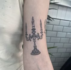 a woman with a tattoo on her arm has a candle and two candles in it