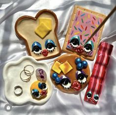 there are some cookies and other items on the bed together, such as an earring holder