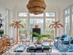 a living room filled with lots of furniture next to large windows covered in wicker