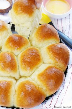 a person holding a piece of bread in the middle of a bun on a plate