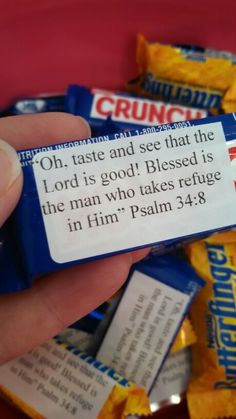 a hand holding a small blue candy bar with the words, oh, taste and see that the lord is god's blessing