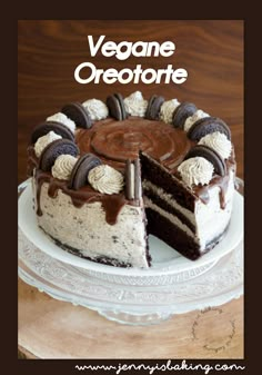 a cake with chocolate and oreo cookies on top is sitting on a white plate