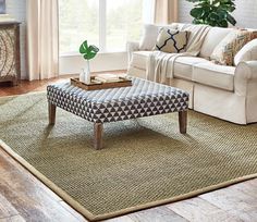 a living room with a couch, coffee table and rugs on the hardwood floor