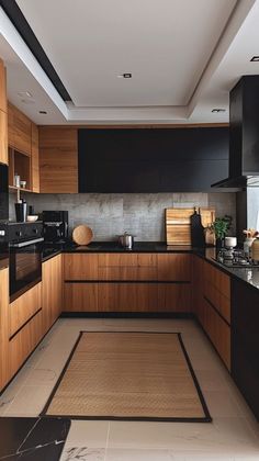 a kitchen with wooden cabinets and black counter tops, along with an area rug on the floor