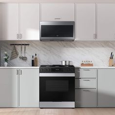 a stove top oven sitting inside of a kitchen next to white cabinets and counter tops