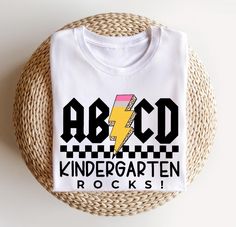 a white t - shirt with the words abcd and a lightning bolt on it