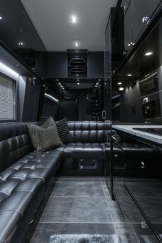 a black couch sitting in the middle of a living room next to a counter top