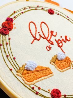 a close up of a embroidery on a piece of cloth with the word joy written in it