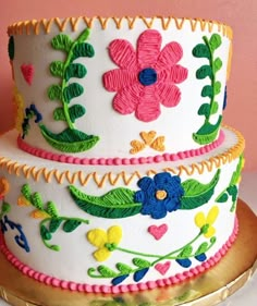 a three layer cake decorated with flowers and music notes