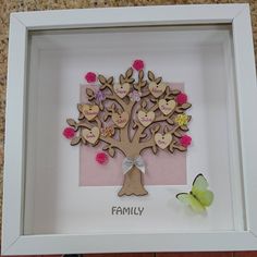 a family tree in a frame with butterflies on the floor and a butterfly sitting next to it