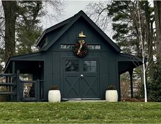 a black barn with a wreath on the front door