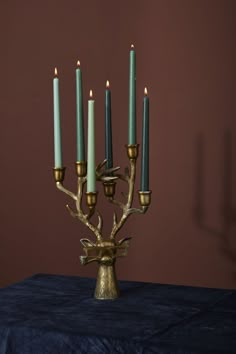 a candelabra with five candles in it on a blue cloth tablecloth