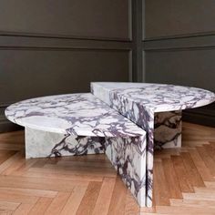 two marble tables sitting on top of a wooden floor