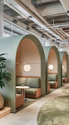 an office with green and beige booths, plants and potted plants on the floor