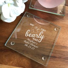 a glass plaque sitting on top of a wooden table next to a vase with flowers