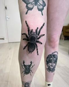 a woman's legs with tattoos on them and two bugs in the middle of her leg