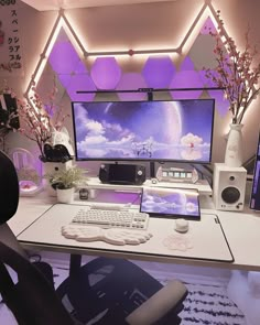 a desk with a computer, keyboard and mouse on it in front of a large screen