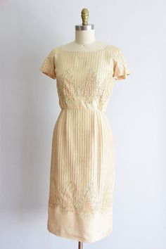 "Vintage 1950s wiggle dress. Buttercream silk with pleated bodice and skirt. Capped sleeves and eight large cream appliqué throughout the top and bottom. Nipped waist followed by straight skirt. Side metal zipper closure. State of garment | very good, faint tiny stains on bodice, faint underarm staining, and 1/4 little shining area on left shoulder (can easily be patched). item has not been cleaned. Measurements ✂--- best fit | small bust | up to 36\" shoulders | 14\" shoulder to waist | 15.5\" Vintage Dresses With Pleated Bodice For Vintage Events, Vintage Pleated Dresses With Fitted Bodice, Vintage Pleated Formal Dress, Silk Cream Dress For Vintage Events, Cream Silk Dress For Vintage Events, 1950s Style Cream Summer Dress, Cream 1950s Style Vintage Dress, Cream Fitted 1950s Style Dress, Cream Fitted Dress In 1950s Style