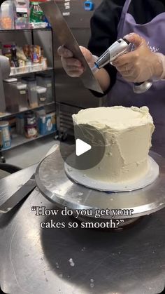 a person cutting a cake on top of a metal tray with a knife in it