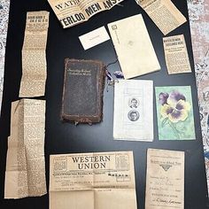 an assortment of old newspapers and papers laid out on top of a black tablecloth